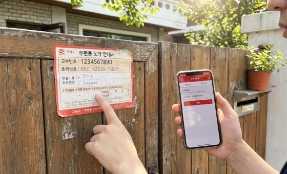 대문 앞에 붙어있는 우체국 우편물 도착 안내서 스티커와 교부번호 확인 모습