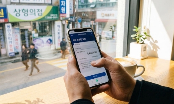 스마트폰 보험사 앱에서 해지 환급금 조회 화면을 보여주는 손